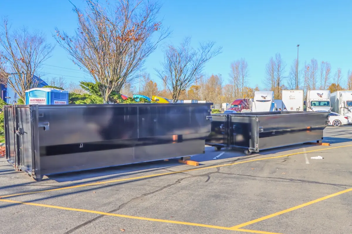 Professional dumpster rental service with roll-off container on residential driveway in Logansport